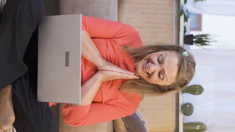 Vertical-video-of-Woman-looks-at-laptop-and-rejoices.